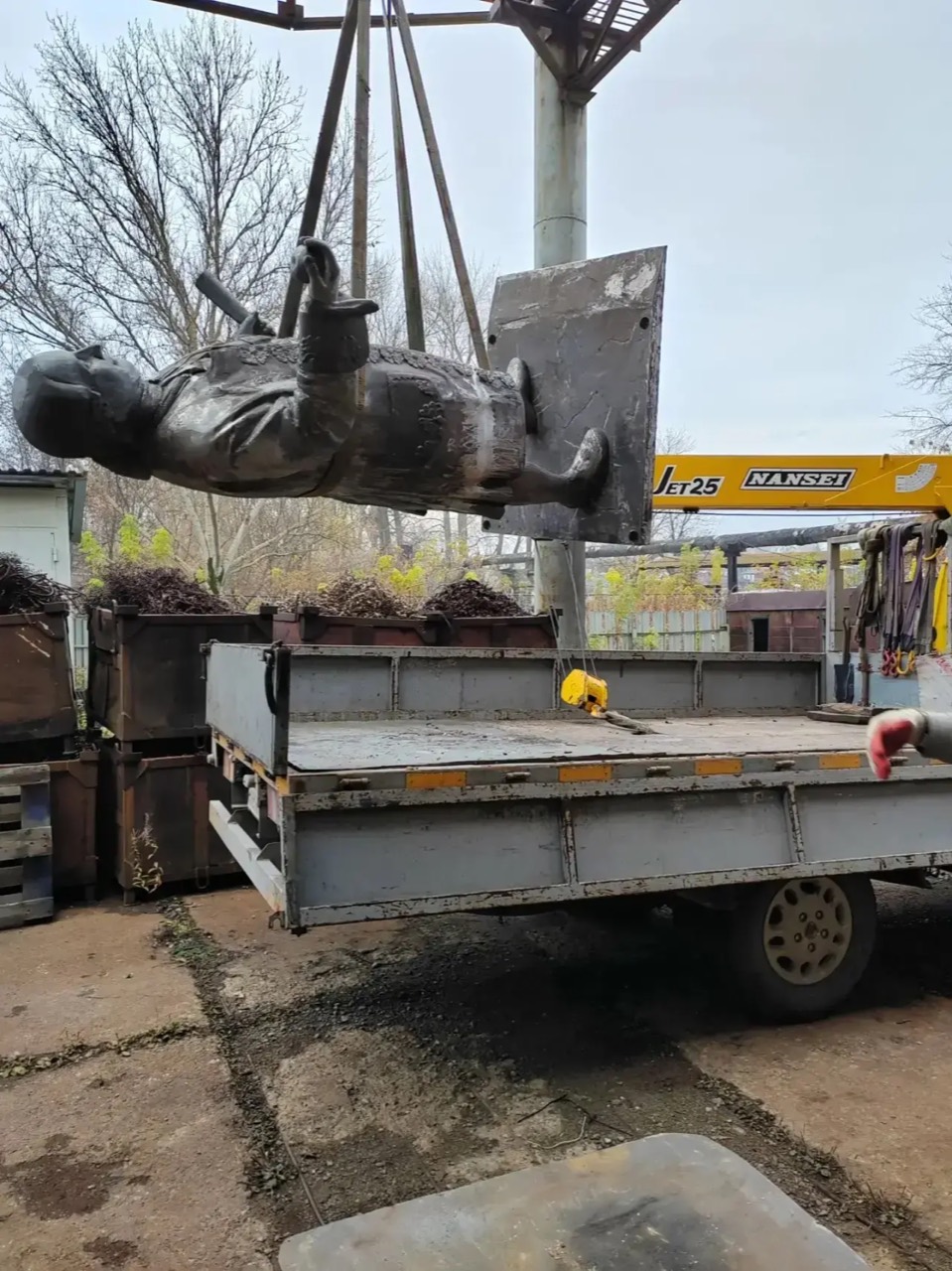 Скульптуру на стропах поднимают над платформой грузового автомобиля