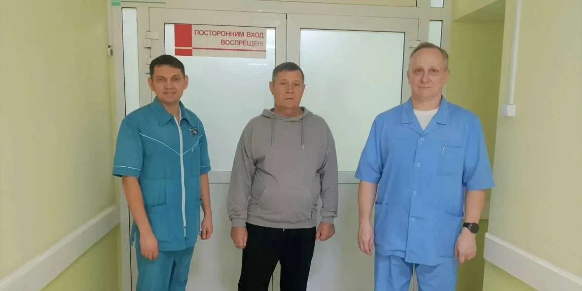 Двое медработников и мужчина в больничном коридоре