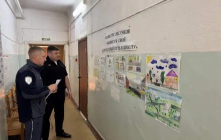 Сотрудники Госавтоинспекции рассматривают детские рисунки безопасного пути в школу
